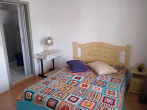 um quarto com uma cama com uma cabeceira de madeira em Apartamento para casal. Perto do mar em Tramandaí