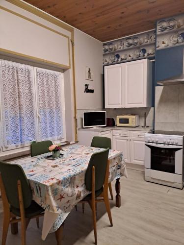 une cuisine avec une table et des chaises et une cuisine avec des placards blancs dans l'établissement Appartement tout confort, à Boulogne-sur-Mer