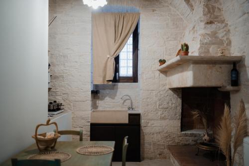 a kitchen with a table and a sink and a fireplace at DOMUS Casa Vacanze in Terlizzi