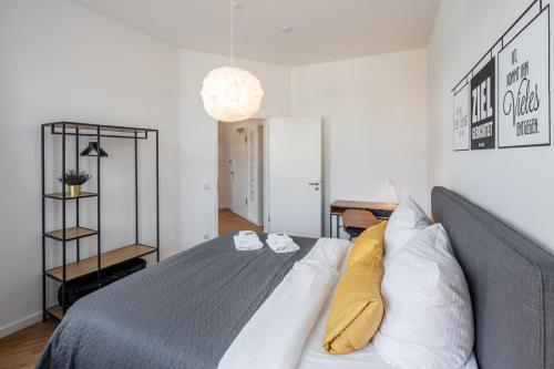 a bedroom with a bed with white and yellow pillows at Goethe Palais Suite Anna Amalia l 1-8P l Lift l Parkplatz in Aue