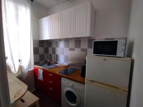 une petite cuisine avec un réfrigérateur et un micro-ondes dans l'établissement Charmant Studio - 10 mn de Paris, à Vitry-sur-Seine