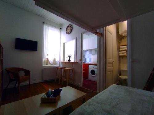 uma pequena sala de estar com uma cozinha e uma mesa em Charmant Studio - 10 mn de Paris em Vitry-sur-Seine