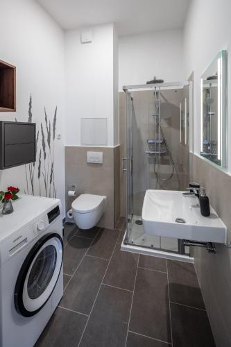 a bathroom with a washing machine and a sink at Goethe Palais Suite Anna Amalia l 1-8P l Lift l Parkplatz in Aue