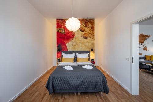 a bedroom with a bed and a painting on the wall at Goethe Palais Suite Anna Amalia l 1-8P l Lift l Parkplatz in Aue