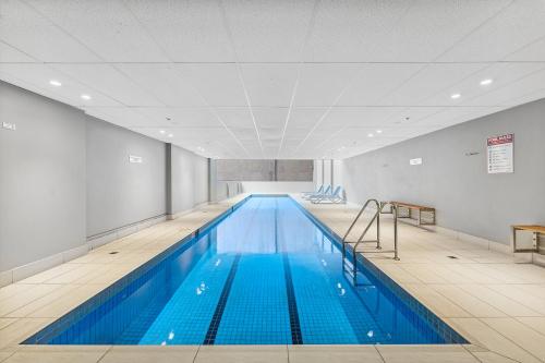 a large swimming pool with blue water in a building at APX World Square in Sydney