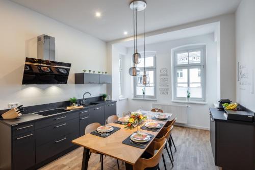 a kitchen with a table and chairs in a kitchen at Goethe Palais Suite Anna Amalia l 1-8P l Lift l Parkplatz in Aue