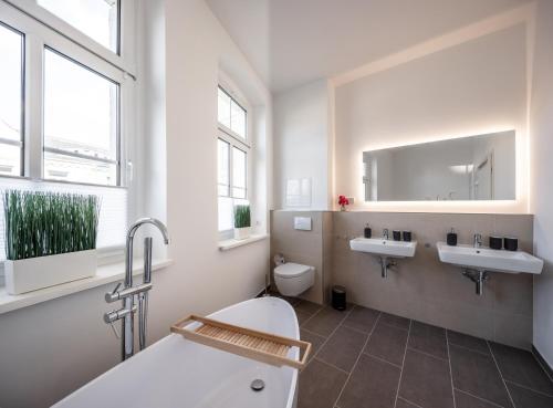 a bathroom with two sinks and a toilet at Goethe Palais Suite Anna Amalia l 1-8P l Lift l Parkplatz in Aue