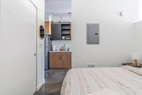 um quarto branco com uma cama e uma cozinha em Seattle Lux 1 bd Apartment- Rooftop, WiFi, Pet Friendly em Seattle