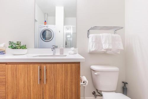 a bathroom with a sink and a washing machine at Seattle Lux 1 bd Apartment- Rooftop, WiFi, Pet Friendly in Seattle