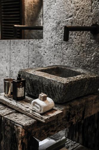 a bathroom with a stone sink and a towel at Kenoa Exclusive Beach Spa & Resort in Barra de São Miguel