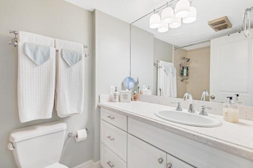 Un baño blanco con lavabo y espejo. en Wolf Lodge 510, en Eden