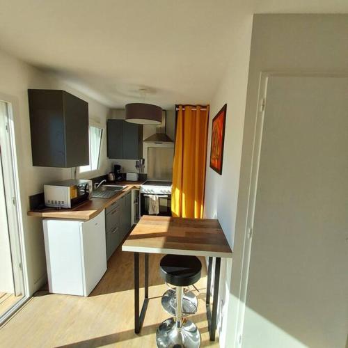 - une petite cuisine avec une table et un comptoir dans l'établissement Studio avec terrasse et jardin à 100 m de la plage de Fort Bloqué, à Ploemeur