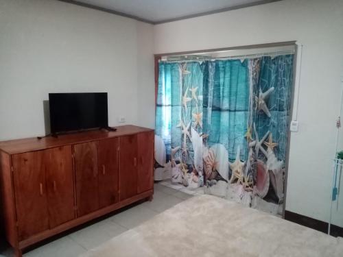 salon z telewizorem i komodą w obiekcie La Casita w mieście Dos Brazos