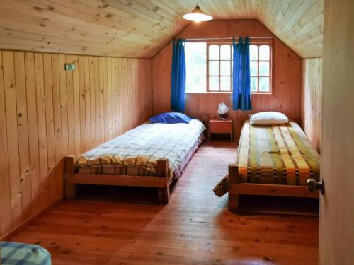 um quarto com 2 camas e uma janela em Cabaña Radal en Coñaripe cerca del lago Calafquén em Coñaripe