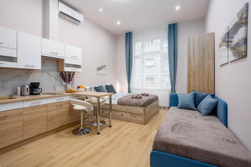 GoodWind Aparthotel - We believe in high standards في بودابست: غرفة نوم بسرير ومكتب ومطبخ