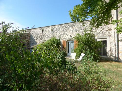 a stone house with two white chairs in the yard at Mas du Crès in Galargues