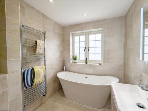 a bathroom with a white tub and a sink at The Hive - Pet Friendly House - Emsworth in Emsworth