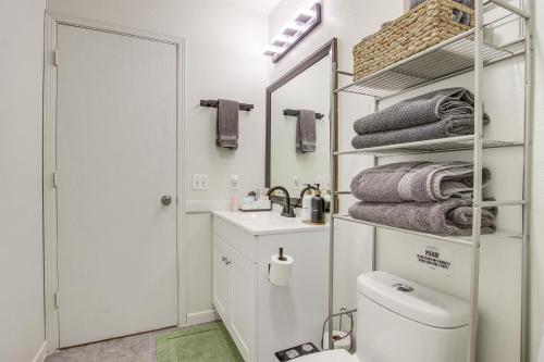 a bathroom with a toilet and a sink and a mirror at Centrally Located Apt about 2 Mi to University of Iowa in Iowa City