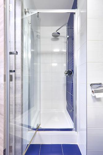 a shower with a glass door in a bathroom at Hotel City Center in Brussels