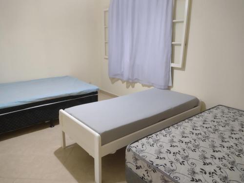 mały pokój z 2 łóżkami i stołkiem w obiekcie Apartamento 2 quartos em Conservatória - até 7 pessoas! w mieście Conservatória