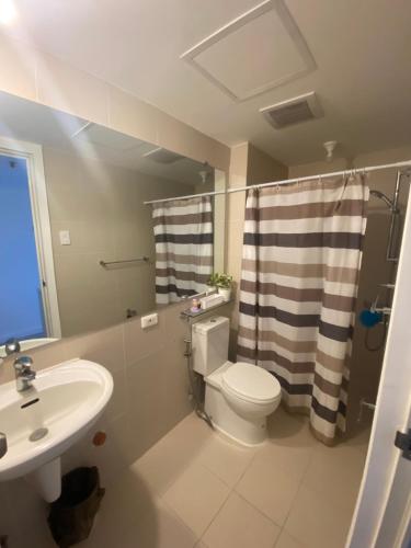 a bathroom with a toilet and a sink at AzureNorth 17F Mt Arayat View in Del Rosario