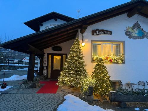 een huis met twee kerstbomen ervoor bij La Roche Hotel Appartments in Aosta