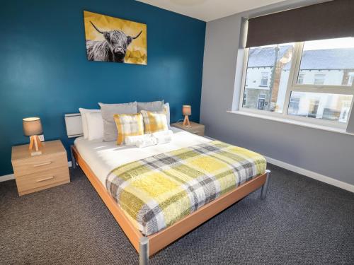 a bedroom with a bed and a blue wall at Lytham Place in Preston