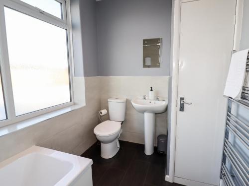 a white bathroom with a toilet and a sink at Lytham Place in Preston