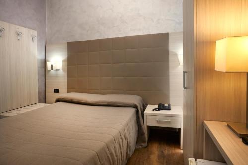 a small bedroom with a bed and a night stand at Hotel Galimberti in Turin