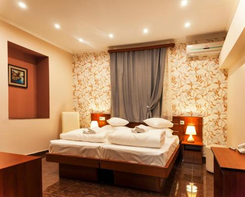 1 dormitorio con 2 camas y ventana en Mia Casa Hotel Yerevan, en Ereván
