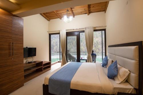 a bedroom with a large bed and a large window at Allure lake front in Nainital