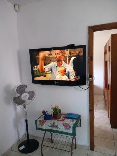 a flat screen tv hanging on a wall at Apartamento família perto do mar in Tramandaí