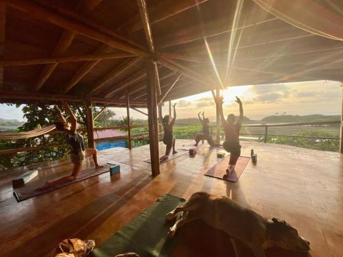a group of people doing yoga on the floor of a building at Vistamar Guest House in Ayampe