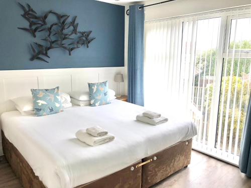 sypialnia z dużym łóżkiem z ręcznikami w obiekcie The Salty Dog holiday cottage, Camber Sands w mieście Rye