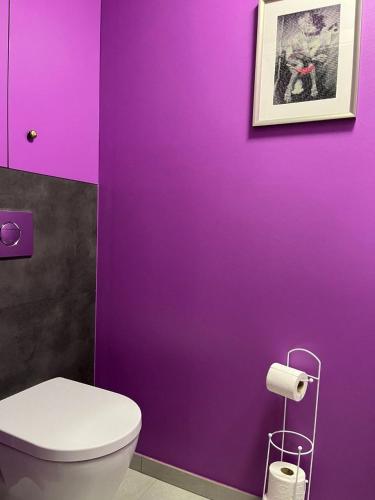 a purple bathroom with a toilet and a purple wall at Studio Les Champs in Baelen