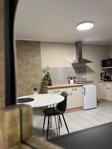 a kitchen with a table and a christmas tree in it at Studio Les Champs in Baelen