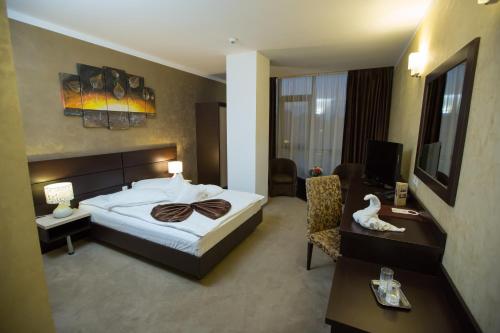 Habitación de hotel con cama y sala de estar. en Hotel Meliss en Craiova