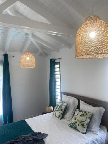 a bedroom with a bed with blue curtains and two lamps at Gîte prestige-Colin in Petit-Bourg