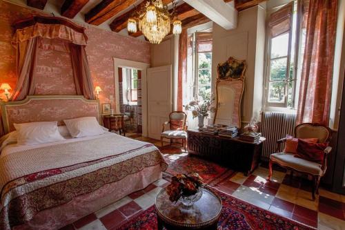 a bedroom with a large bed and a chandelier at Manoir de Boisairault in Le Coudray-Macouard
