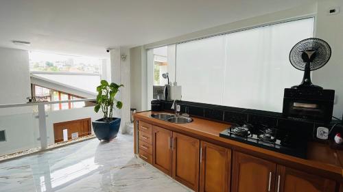 a kitchen with a sink and a large window at Espaço Nobre in Cunha
