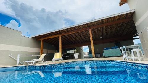 a swimming pool with two chairs next to a building at Espaço Nobre in Cunha