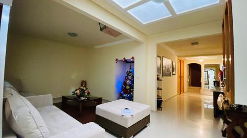 a living room with a white couch and a christmas tree at Espaço Nobre in Cunha