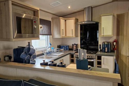 a kitchen with a sink and a counter top at Contemporary home at Tarka Holiday Park Barnstaple in Barnstaple