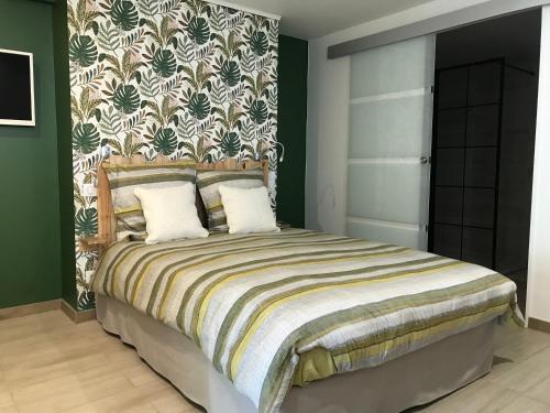 - une chambre avec un grand lit et un mur vert dans l'établissement Studio neuf de 24m², à Brive-la-Gaillarde