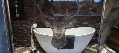 a deer head on the side of a bath tub at no 7 boutique apartment in Ulverston
