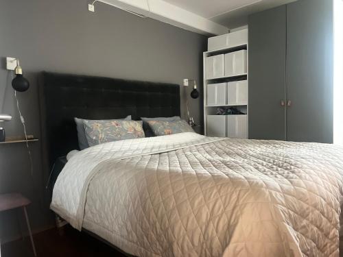 een slaapkamer met een groot bed met een zwart hoofdeinde bij Copenhagen in 8tallet in Kopenhagen