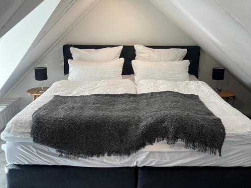 a black and white bed with a black blanket on it at Zeitapartments Altstadtlage in Stade