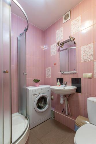 a pink bathroom with a washing machine and a sink at Covent - Garden - Kharkiv in Kharkiv