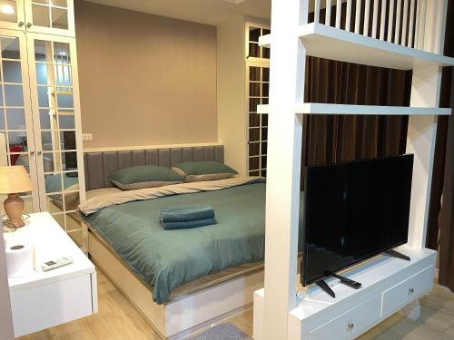 a bedroom with a bed and a flat screen tv at Easy Easy @ the patio in Ban Bang Saen (1)