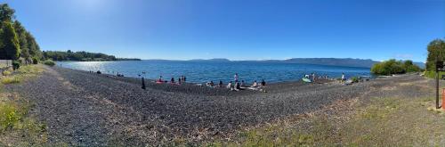 un grupo de personas sentadas en la orilla de un lago en Cabañas Loncotraro, en Pucón